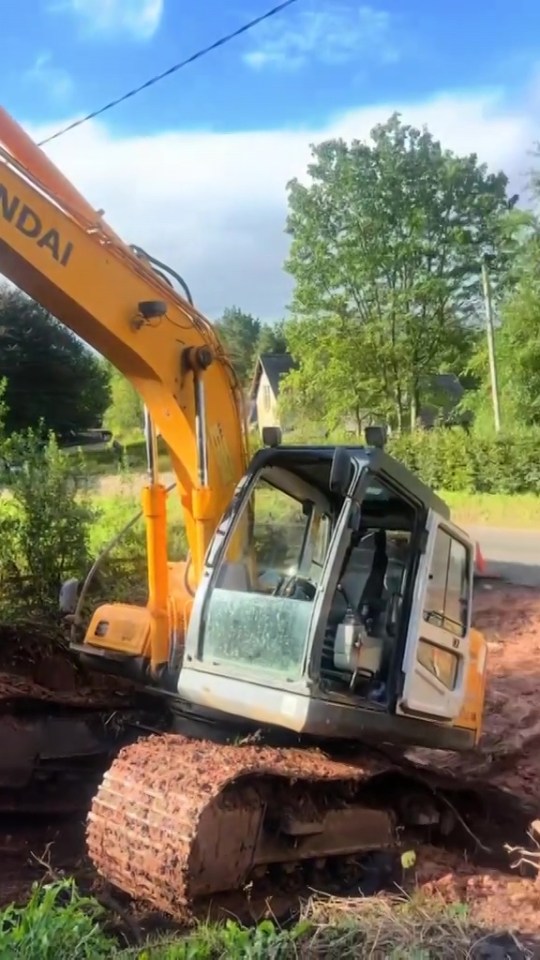 a yellow hyundai excavator is sitting in the dirt