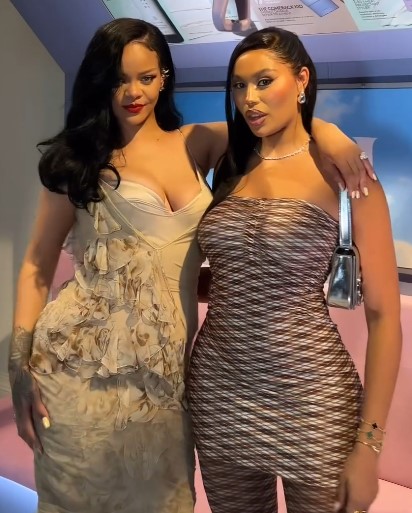 two women standing next to each other with one wearing a strapless dress