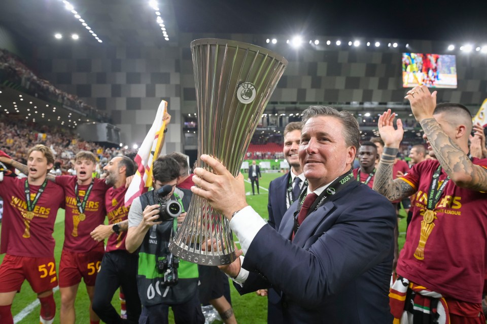 a man holds up a trophy with the word uefa on it