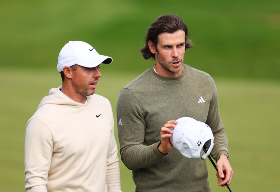 two men standing on a golf course one wearing an adidas shirt