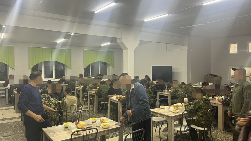 a group of soldiers are sitting at tables in a dining room