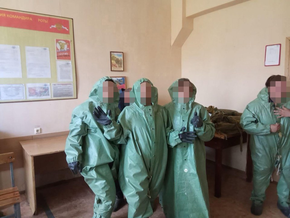 a group of people standing in front of a bulletin board that says " роли "