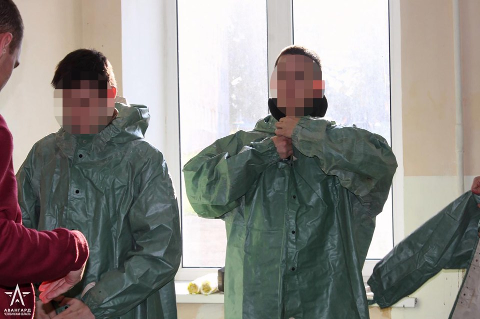 two people are standing in front of a window and their faces are obscured by a russian army logo