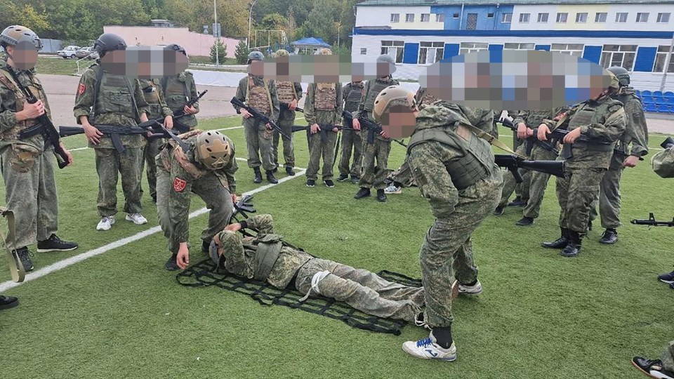 a group of soldiers are standing around a man laying on a stretcher