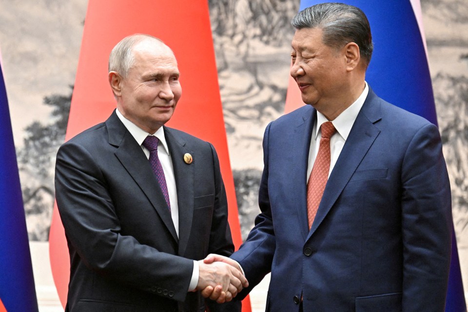 a man in a suit and tie shakes hands with another man