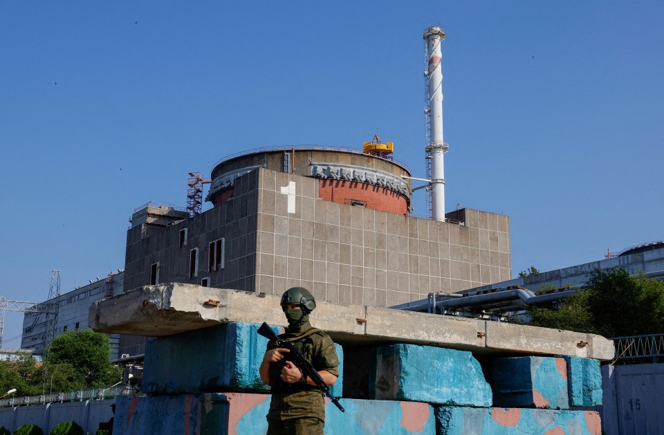 A Russian service member stands guard at a checkpoint near the Zaporizhzhia nuclear power plant