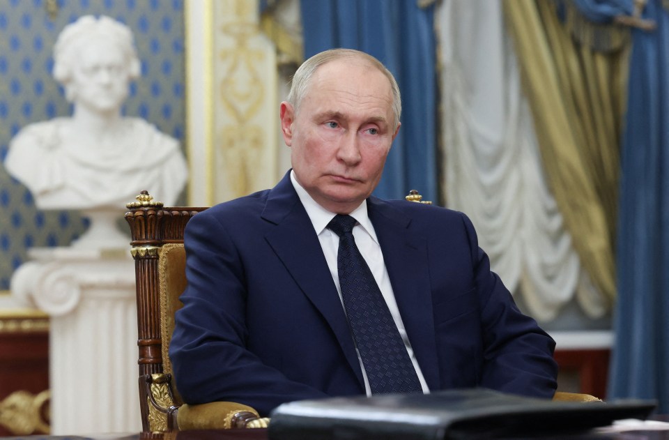 a man in a suit and tie sits in a chair