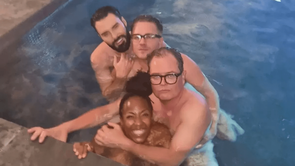 a group of people are posing for a picture in a pool