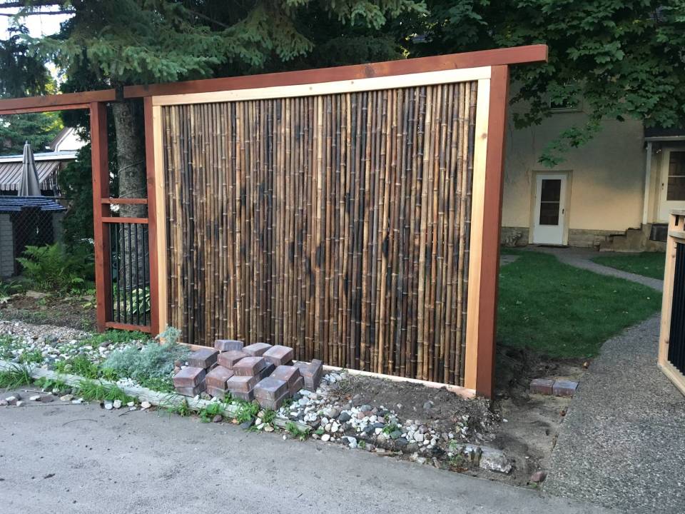 a fence made of bamboo is being built in front of a house