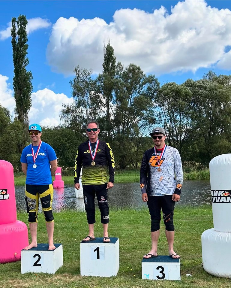 three men are standing on a podium with numbers 1 2 and 3