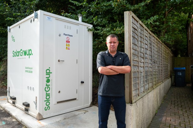 a man stands in front of a solar group building