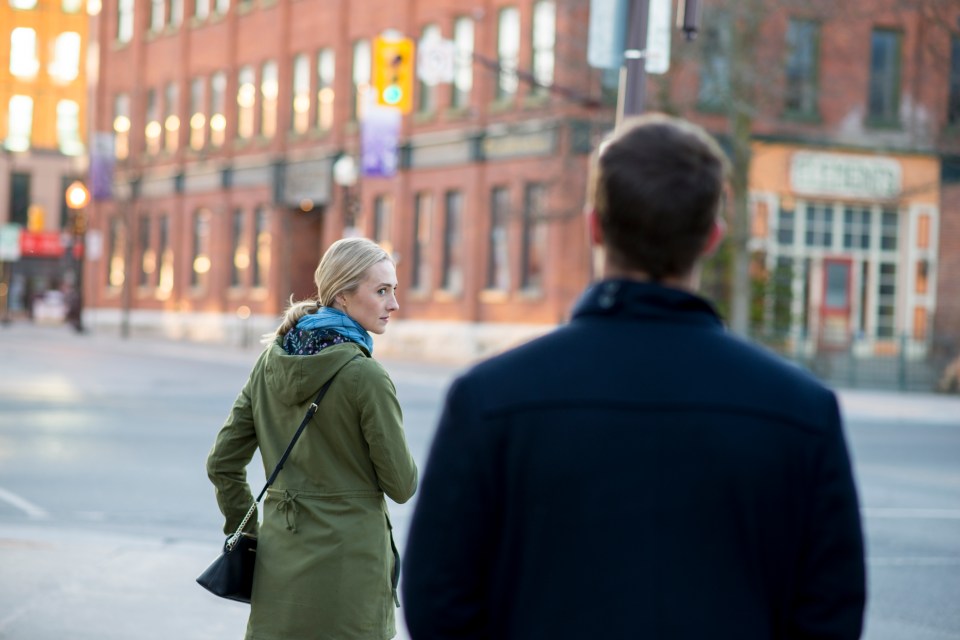 a man and a woman are walking down a street in front of a building that says fresh