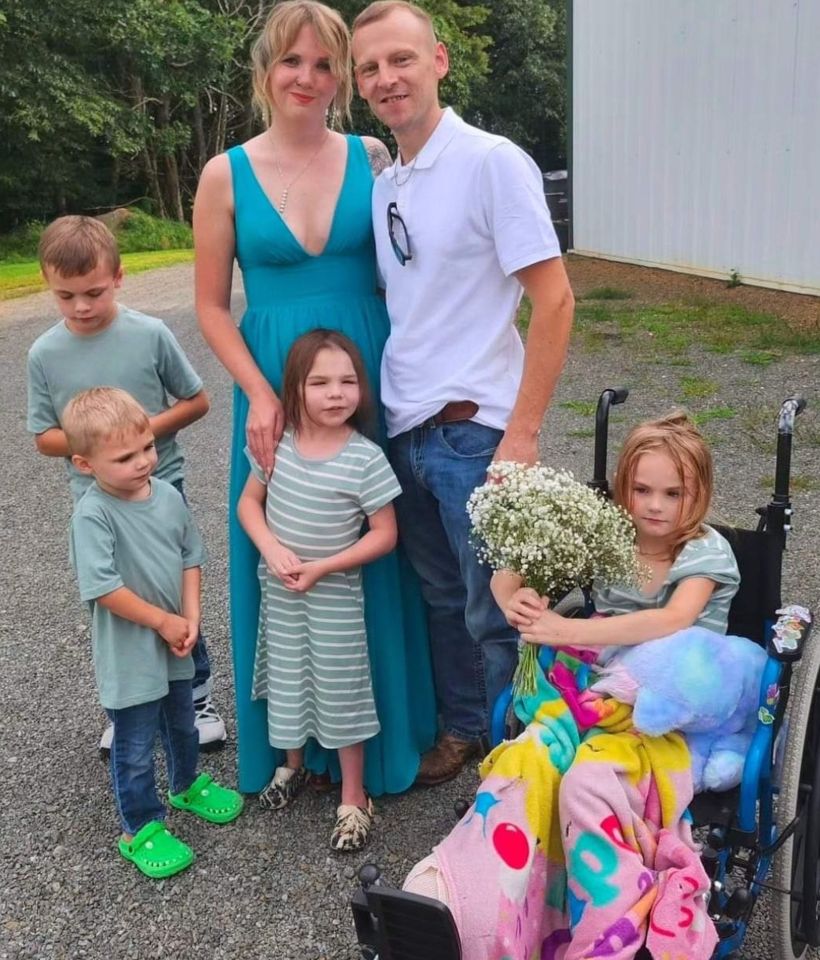 a family posing for a picture with a girl in a wheelchair