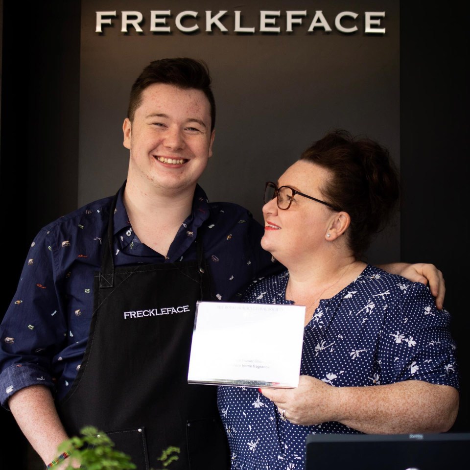 two people standing in front of a sign that says freckleface