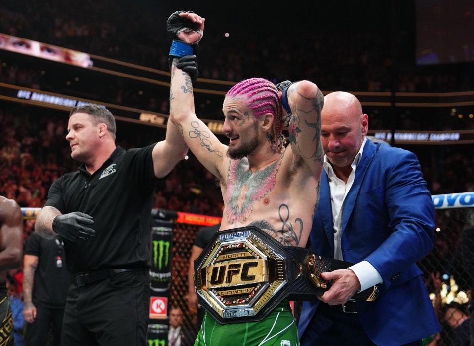 a man with pink hair is holding a ufc belt