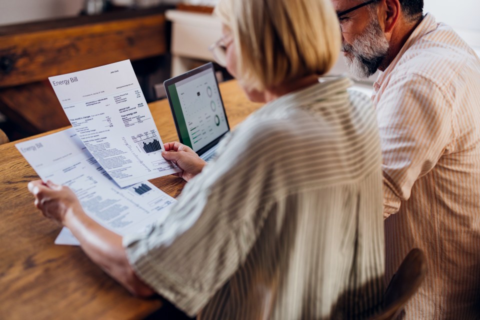 a man and woman are looking at an energy bill