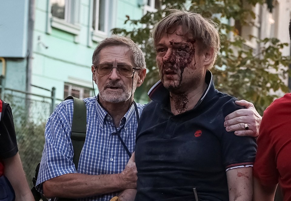 A bloodied Yaroslav Bazylevych is comforted after his entire family were killed in a Russian strike on Lviv