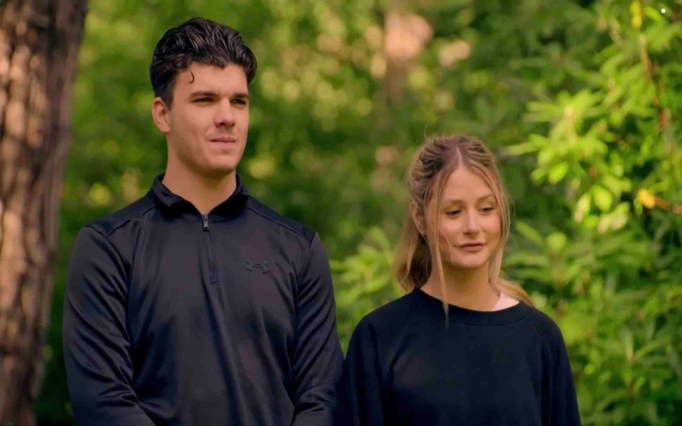 a man in a black under armour shirt stands next to a woman