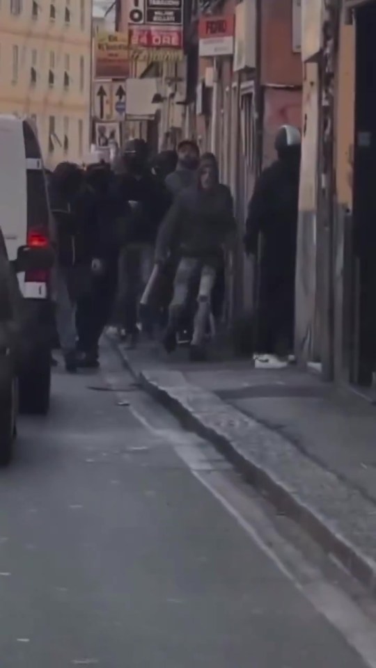 a group of people are walking down a street in front of a store that says fendi