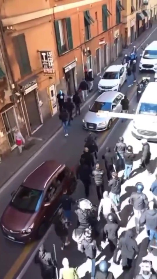 a group of people are walking down a street in front of a store called tabaco