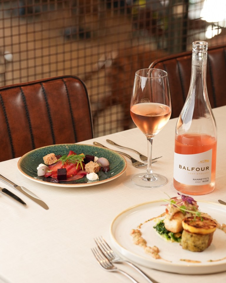 a bottle of balfour wine sits on a table next to a plate of food