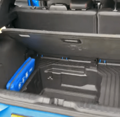 the trunk of a blue car with a blue box in it .