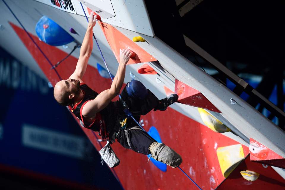 a man is climbing a wall with a sign that says ' main ' on it