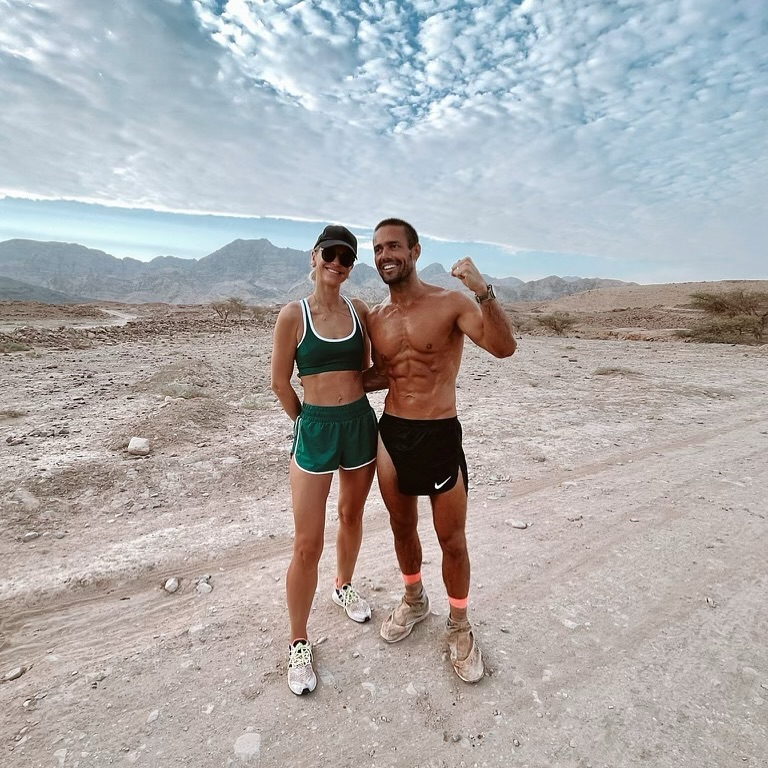 a man and a woman are posing for a picture in the desert