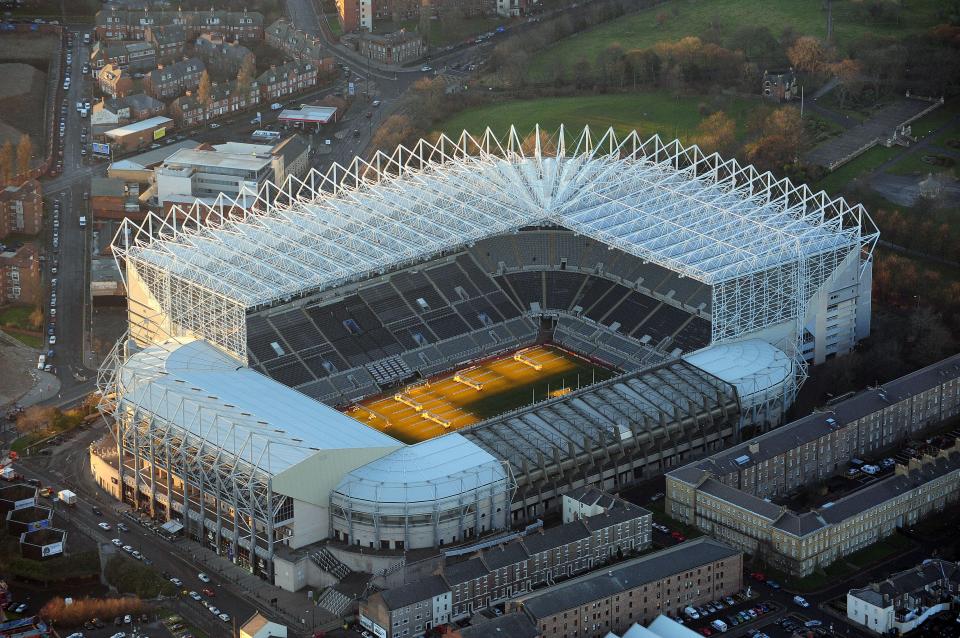 an aerial view of a stadium with a yellow field in the middle