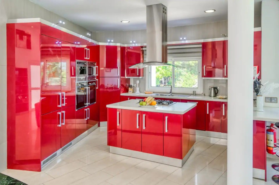 a kitchen with red cabinets and a stove top oven