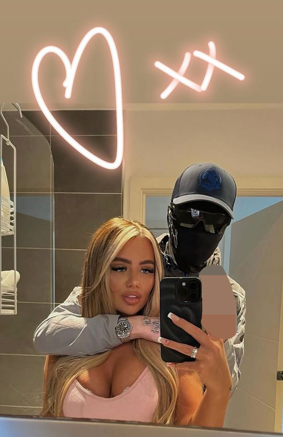 a woman taking a selfie with a man in a mask