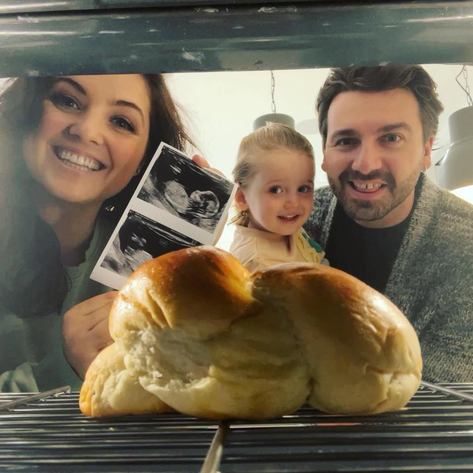 a family holding a picture of a baby and a loaf of bread