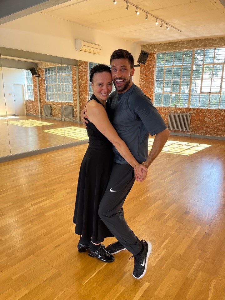 a man and a woman are posing for a picture in a dance studio