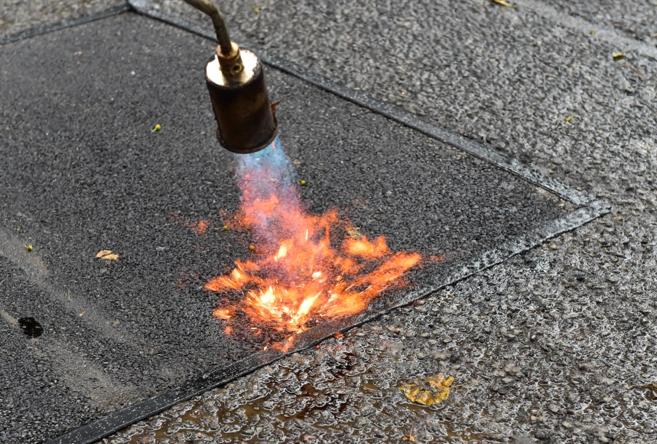 Heat torch softens the asphalt to make it conform to contours of pothole for a seamless join