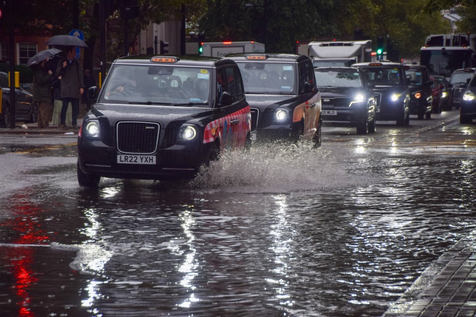 Taxis splash through a waterlogged Euston Road in London