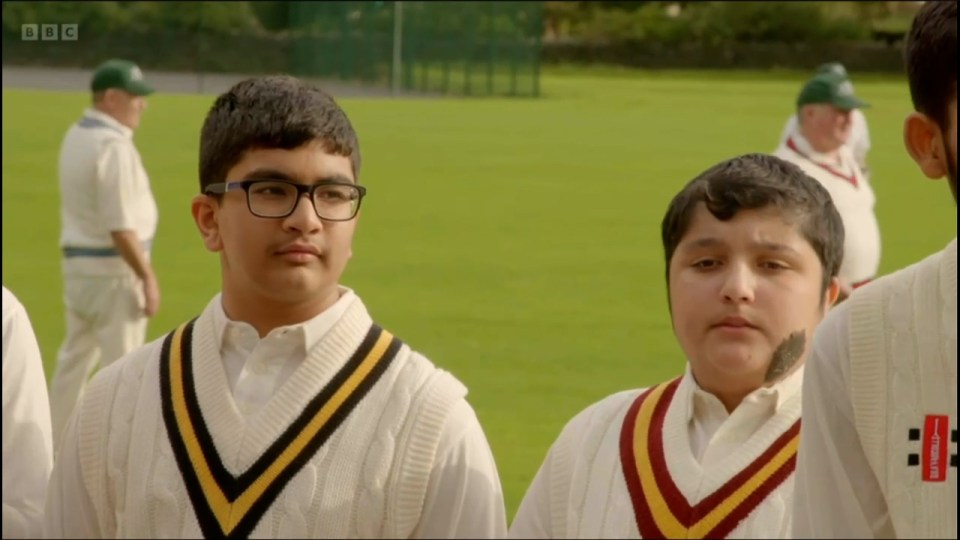 a boy wearing a sweater that says kingfisher on it