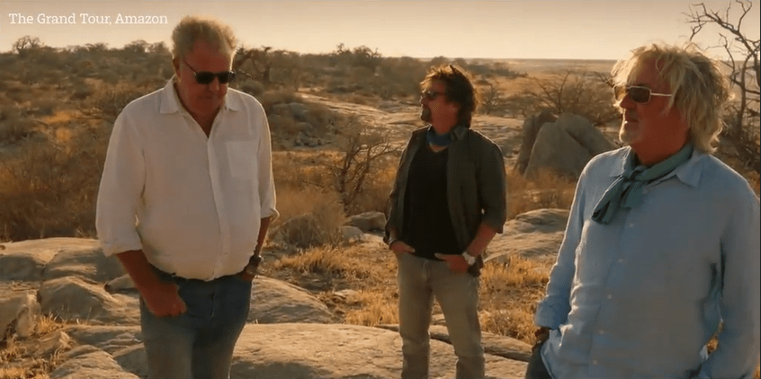 three men standing in a field with the grand tour amazon on the bottom