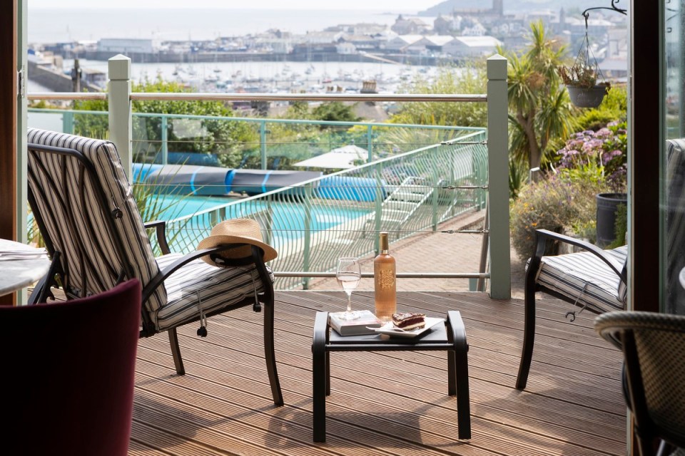 a bottle of rose wine sits on a table on a deck