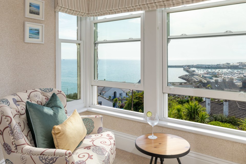 a chair in front of a window with a view of the ocean