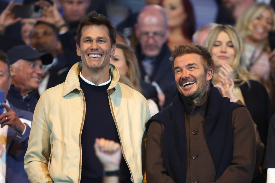 two men are smiling in front of a crowd of people