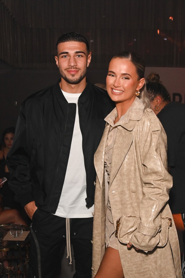 a man and a woman pose for a picture in a dark room