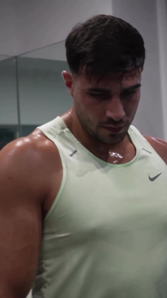 a man in a green nike tank top is sweating