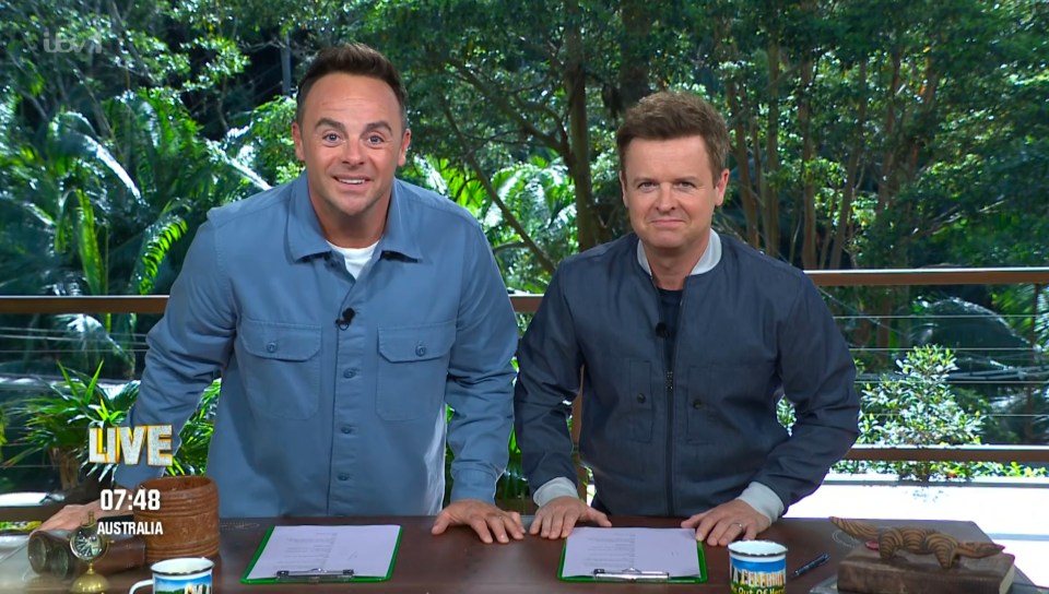 two men standing next to each other in front of a sign that says live