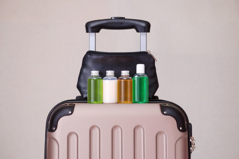 a suitcase with four bottles of liquid on it