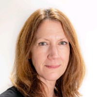 a woman with long red hair is smiling for the camera .