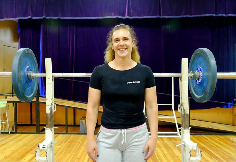 a woman stands in front of a barbell wearing a shirt that says safety first