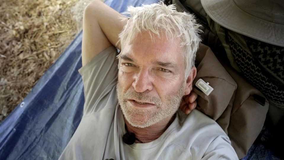 a man with white hair and a beard is laying on a blue tarp