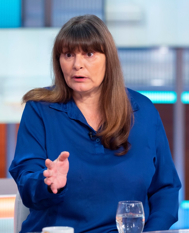 a woman in a blue shirt is sitting at a table with a glass of water