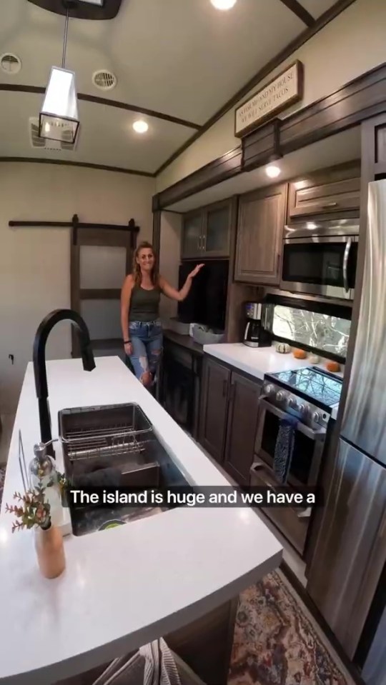 a woman in a kitchen with a sign that says " the island is huge and we have a "