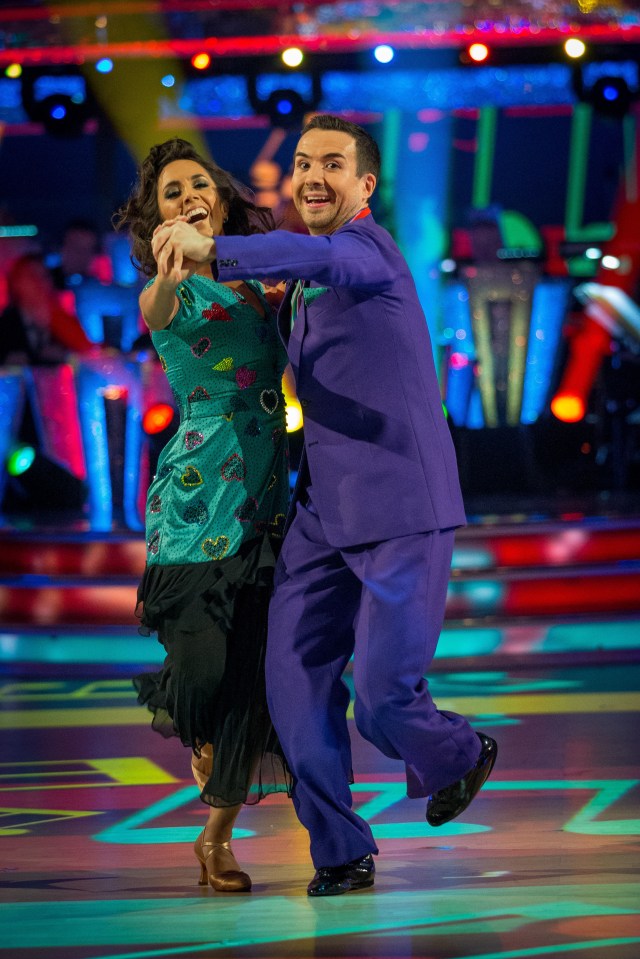 a man in a purple suit is dancing with a woman in a blue dress